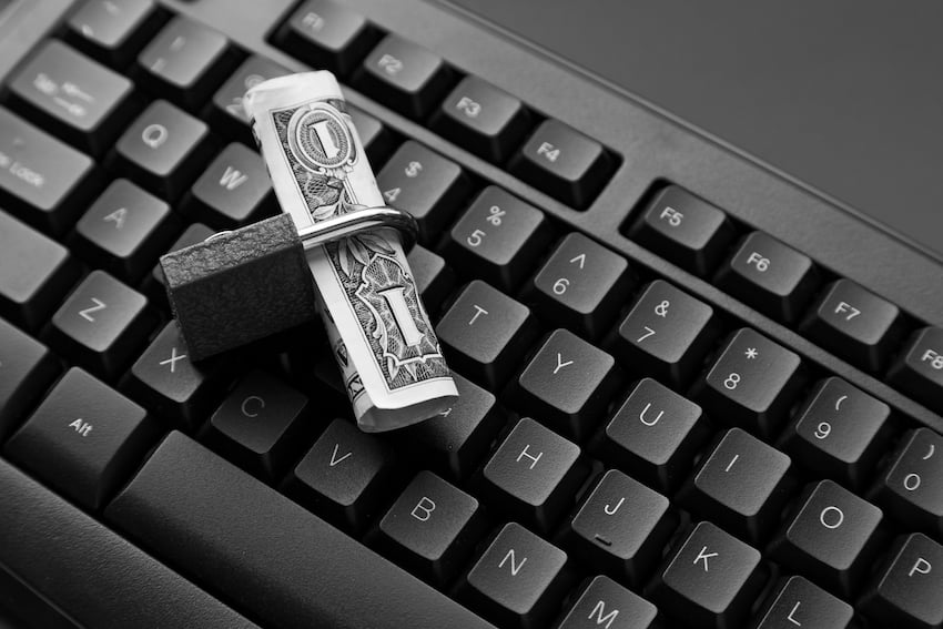High-angle-shot-of-a-lock-around-a-dollar-bill-on-a-black-laptop-1.jpg