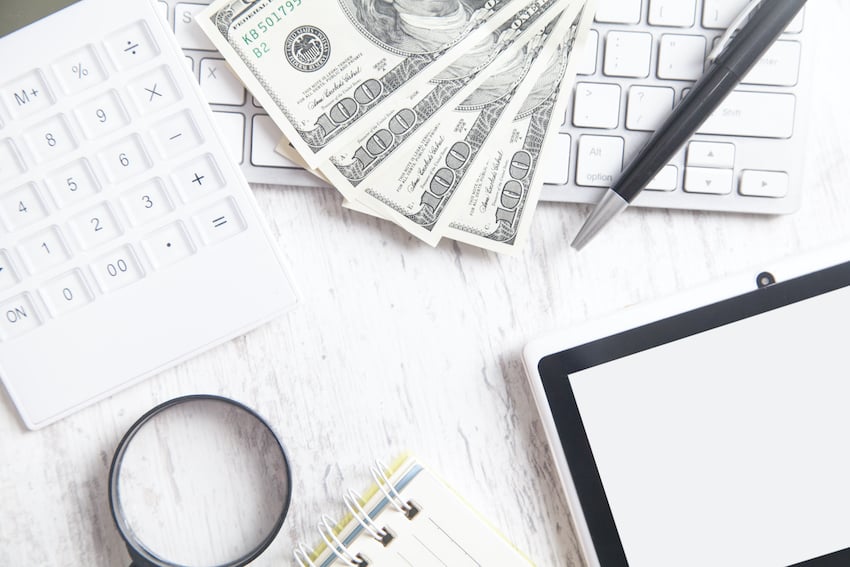 Hundred-dollar-banknotes-with-a-computer-keyboard-tablet-and-calculator-top-view.jpg