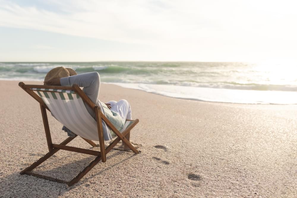Relaxed-retired-senior-biracial-woman-sitting-folding-chair-enjoying-sunset-beach-lifestyle-weekend-scaled-1.jpg