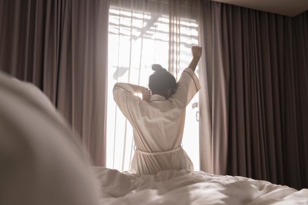 White-dress-asian-female-beautiful-woman-stretching-morning-wake-up-freshness-carefree-weekend-moment-cosy-interior-bedroom-with-white-curtain-sun-shine-background-lifestyle-home-concept-scaled-1.jpg